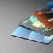 A stack of various credit cards arranged on a dark surface, showing different colors and designs.