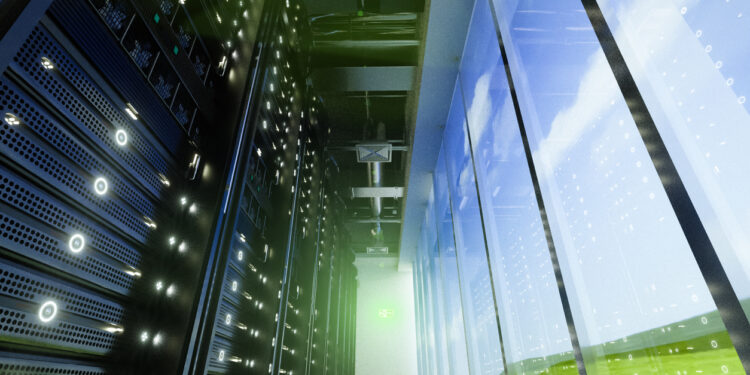 Interior view of a data center showing server racks and large windows with a view of the sky.