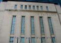 Facade of the Toronto Stock Exchange building featuring large windows and engraved text.