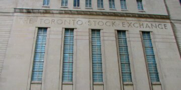 Facade of the Toronto Stock Exchange building featuring large windows and engraved text.