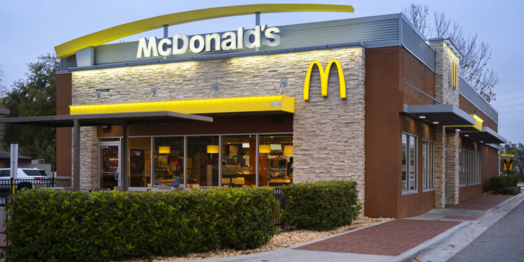 Exterior view of a McDonald's restaurant featuring the iconic golden arches and stone facade.
