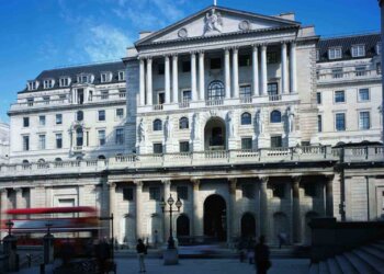 Exterior view of a large bank building with classical architecture and a flag on top.