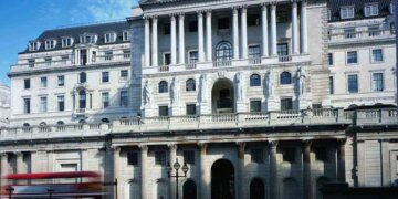 Exterior view of a large bank building with classical architecture and a flag on top.