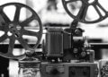 Close-up of a vintage film projector with two large film reels and mechanical components.