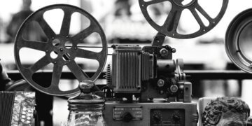 Close-up of a vintage film projector with two large film reels and mechanical components.