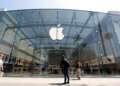 Exterior view of an Apple Store featuring a large glass facade and the Apple logo.
