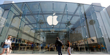 Exterior view of an Apple Store featuring a large glass facade and the Apple logo.