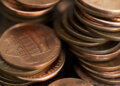 Close-up of a stack of copper coins, primarily showing one-cent coins in a disorganized arrangement.