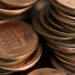 Close-up of a stack of copper coins, primarily showing one-cent coins in a disorganized arrangement.