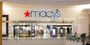 Macy's store entrance with illuminated signage in a shopping mall setting.