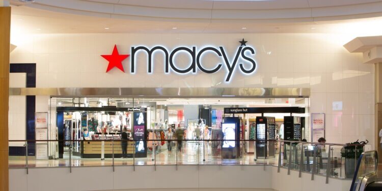 Macy's store entrance with illuminated signage in a shopping mall setting.
