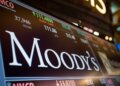 Stock ticker display showing Moody's Corporation with stock price and volume information.