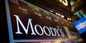 Stock ticker display showing Moody's Corporation with stock price and volume information.