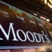 Stock ticker display showing Moody's Corporation with stock price and volume information.