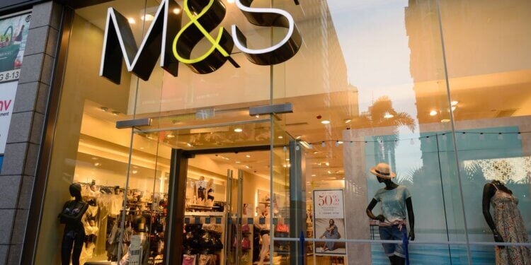 Entrance of an M&S store featuring mannequins and a large sign.