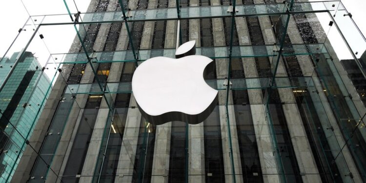 Glass facade of an Apple Store featuring the large Apple logo prominently displayed.