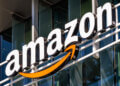 Amazon logo displayed on the exterior of a building with a prominent orange arrow.