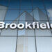 Signage of Brookfield Asset Management displayed on a glass building exterior.