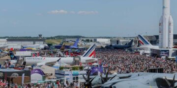 Aerial view of the Paris Air Show 2023 with numerous aircraft and a large crowd of attendees.