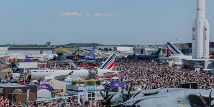 Aerial view of the Paris Air Show 2023 with numerous aircraft and a large crowd of attendees.