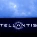 Stellantis logo illuminated on a large screen against a cloudy sky.