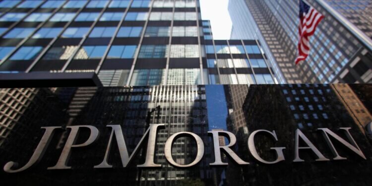 Close-up of the JP Morgan sign on a building with glass architecture in the background.