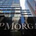 Close-up of the JP Morgan sign on a building with glass architecture in the background.
