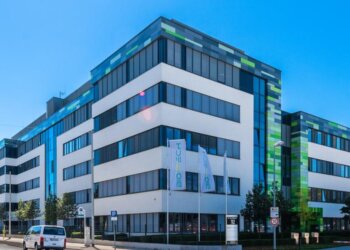 Contemporary office building featuring a mix of white and green architectural elements.