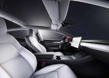 Interior view of a Tesla Model 3 featuring white leather seats and a central touchscreen display.