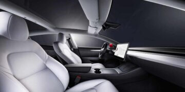 Interior view of a Tesla Model 3 featuring white leather seats and a central touchscreen display.