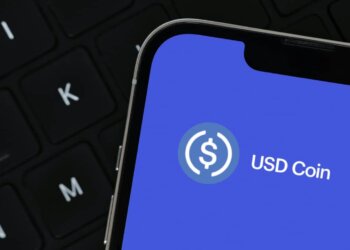Close-up of a smartphone screen showing the USD Coin logo on a blue background.