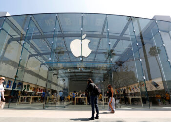 Entrance of an Apple Store featuring a large glass facade and the Apple logo prominently displayed.