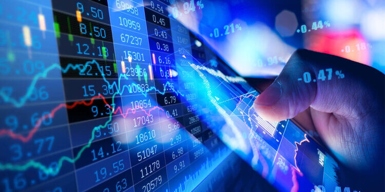 A hand pointing at a digital display of stock market data with graphs and numbers.